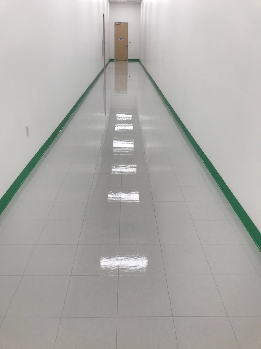 Freshly stripped and waxed VCT corridor with a wet-look shine